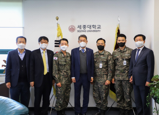 배덕효(가운데) 세종대 총장과 해군 인사참모부장 이수열(왼쪽 세 번째) 소장 등 양측 관계자들이 기념촬영을 하고 있다.  세종대 제공